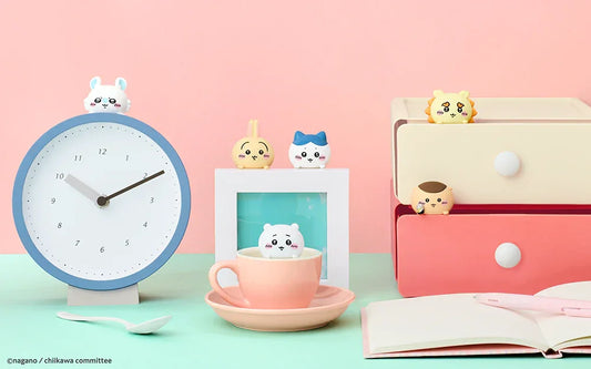 Cute Chiikawa character figurines placed on clock, cup, frame, and drawers with pastel pink and mint background