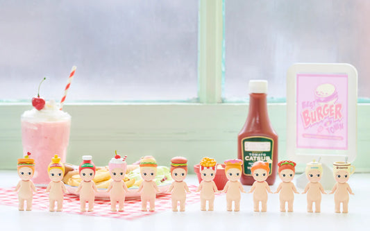Sonny Angel figurines with food-themed hats including burger, ketchup, soda, fries, set on table with milkshake and ketchup bottle