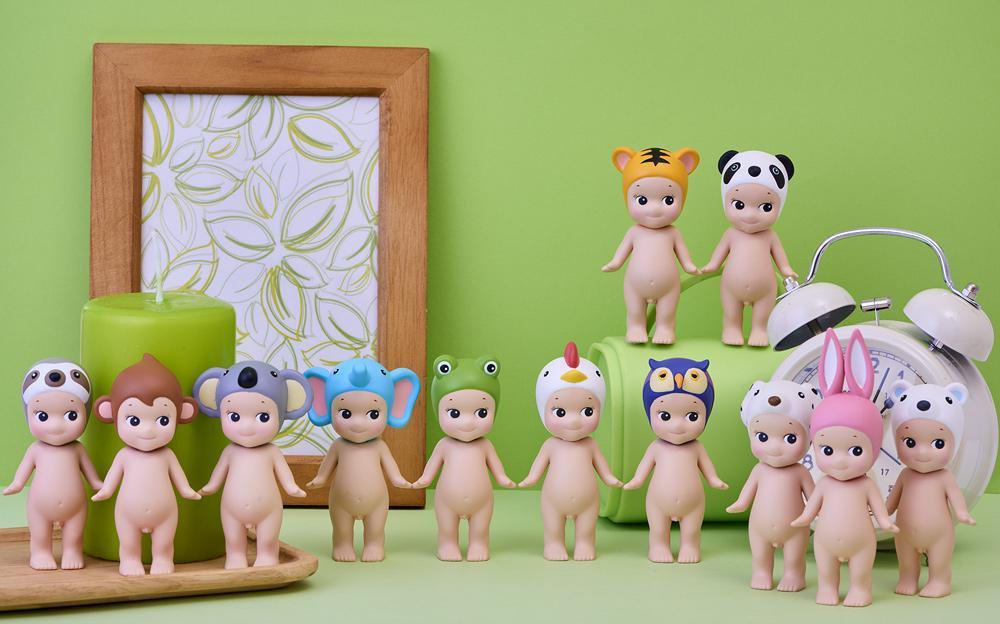Sonny Angel animal series figures including panda, monkey, koala, elephant, frog, chicken, owl, rabbit, tiger, and bear with green background, clock, and candle